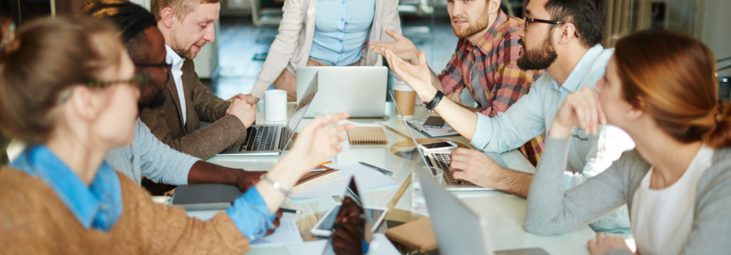 personas sentadas alrededor de una mesa de oficina en una reunión
